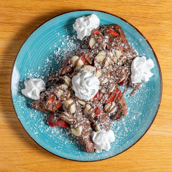 Cafe 26's chocolate-drizzled waffles with strawberries, bananas, powdered sugar, and whipped cream.