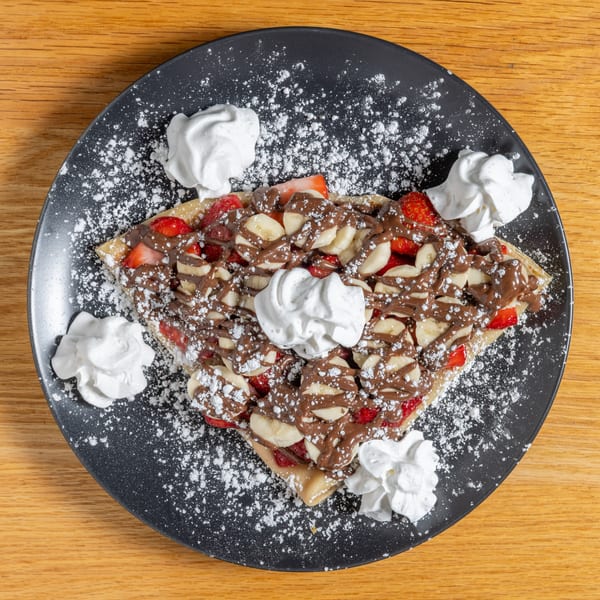 Cafe 26 crepe with strawberries, bananas, chocolate drizzle, whipped cream, and powdered sugar.