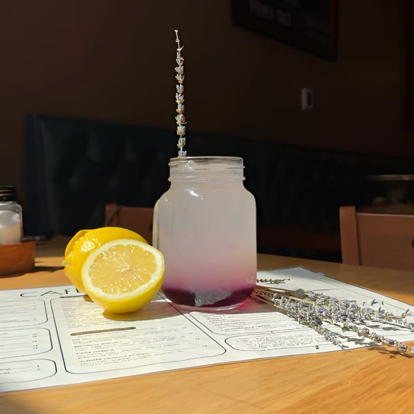 Lavender lemonade in a mason jar with lemons and dried lavender on a Cafe 26 menu.